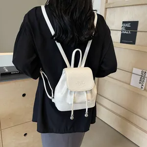 White mini faux leather backpack with drawstring closure and litchi texture