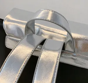 Détails d'un sac à dos argenté brillant avec poignée et coutures de précision