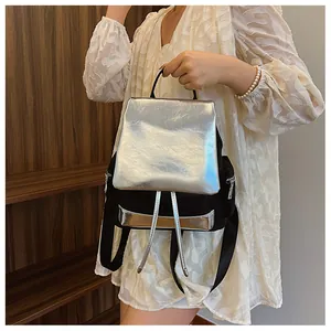 Fashionable contrast silver and black women backpack shown held by a model