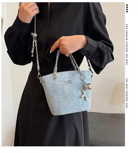 Dettaglio borsa a secchiello in denim celeste con catena d'argento e charm a palloncino