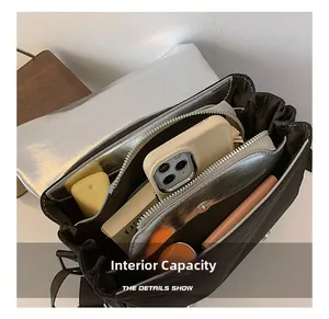 Vue intérieure montrant la grande capacité et le compartiment à fermeture éclair du sac argenté