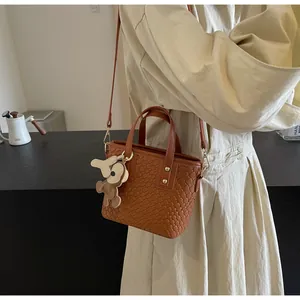 Brown woven tote bag with adjustable shoulder strap and cute bear charm detail