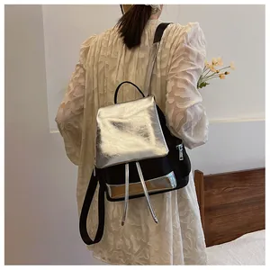 Detail of contrast color backpack with metallic silver flap and black fabric texture