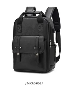 Close-up of black PU leather backpack showing USB port and rivet flap detail