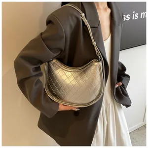 Chic silver metallic quilted hobo bag with adjustable strap worn by a model