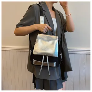Detail of a chic black and silver backpack featuring a metallic flap and side zippers