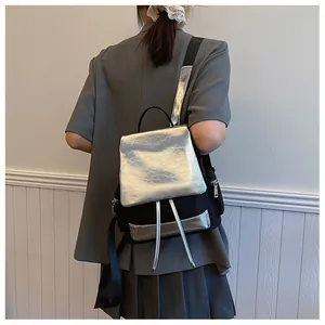 Detail showing the adjustable black strap and silver metallic texture of the modern backpack