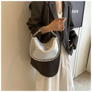 Close-up of silver quilted half-moon bag with metallic leather and elegant chain detail