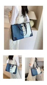 Detailed view of color-block denim tote bag with leather straps on a white dress model