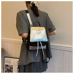 Detail of a large capacity contrast backpack showing metallic silver flap and drawstrings