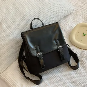 Sac à dos noir classique en matières mixtes avec boucles argentées sur fond gaufré blanc