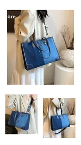 Detail of blue denim patchwork tote bag with leather trim and adjustable strap for women