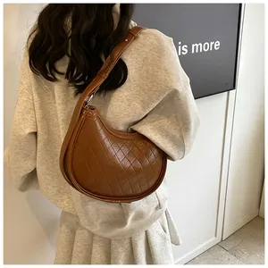 Brown quilted rhombus shoulder bag shown in a stylish back-view model pose