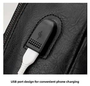 Macro shot of the external USB charging port and pebble grain leather texture on black backpack