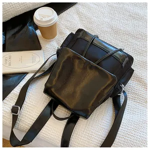 Detail of black contrast backpack with nylon and leather patchwork in a cozy setting