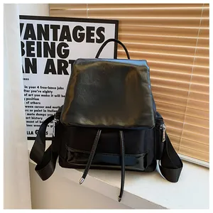 Detail of black contrast backpack showing nylon and faux leather stitching with drawstrings