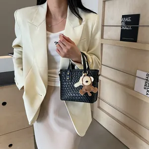 Fashionable black woven mini tote bag with cute bear charm and gold hardware accents