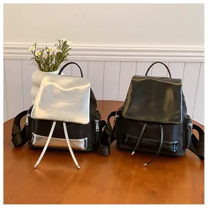 Close-up of contrast color nylon backpacks with metallic flaps on a wooden table