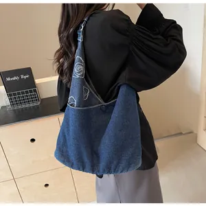 Detail of blue denim tote bag featuring white rose floral pattern and large capacity