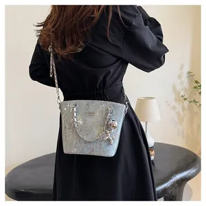 Dettaglio della borsa a spalla in paillettes azzurre con catena d'argento e ciondolo