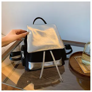 Detail of minimalist contrast backpack with silver flap and black canvas body