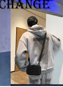 Detail einer schwarzen Hartschalen-Umhängetasche mit Koffer-Rillen und Nylonband