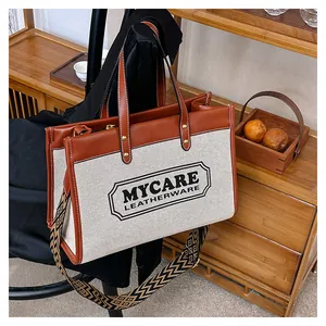 Λεπτομέρεια της κρεμ υφασμάτινης τσάντας tote με καφέ δερμάτινη επένδυση και υφαντό λουράκι