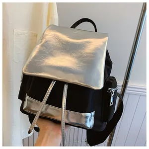 Detailed side view of black nylon backpack with metallic silver flap and zipper pocket