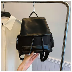 Detail of black contrast backpack featuring premium nylon, leather flap and drawstring closure