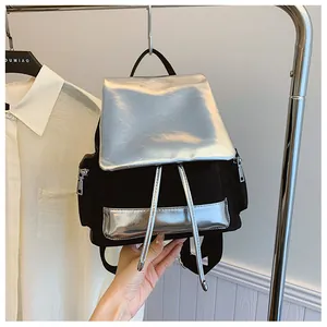 Detail of contrast color backpack with silver metallic flap and durable black fabric