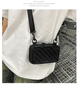 Detail of black hardshell crossbody bag with diagonal grooves and adjustable strap