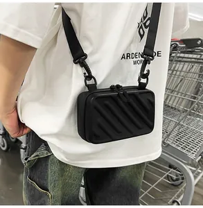 Detail of black hardshell crossbody bag featuring diagonal stripes and dual zippers