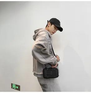 Nahaufnahme eines hellgrauen Oversize-Hoodies mit offenen Kanten und einer Umhängetasche