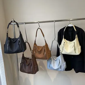 Minimalist textured leather tote bags in five colors hanging on a display stand