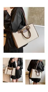 Detail view of canvas tote bag with brown leather trim and metal zipper pocket