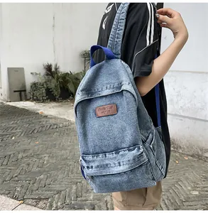 Vue détaillée d'un sac à dos en denim durable avec logo en cuir brun et poche avant