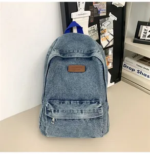 Gros plan d'un sac à dos vintage en jean bleu avec poche avant et écusson en cuir