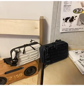Detailansicht der Mini-Koffer Umhängetaschen in Schwarz und Weiß mit Hartschalen-Design