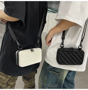 Detail of mini hardshell crossbody bags featuring textured stripes and wide straps
