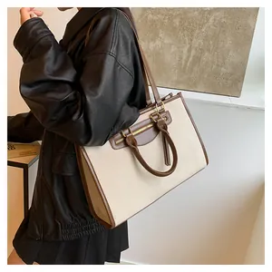 Detail of canvas tote bag showing contrast leather trim and sturdy handle stitching