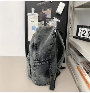 Détail du sac à dos en denim lavé avec poche latérale et texture de tissu robuste