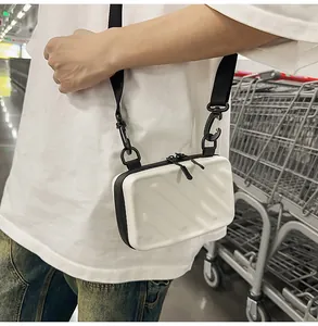 Macro detail of white hard-shell crossbody bag with diagonal stripes and black strap
