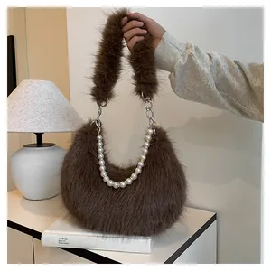 Gros plan d'un sac à bandoulière en peluche marron avec fausse fourrure et chaîne perles