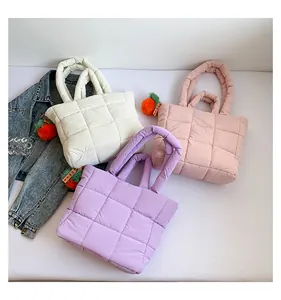 Detailansicht gesteppter Nylon-Tote-Bags in Weiß, Rosa und Lila mit Karotten-Anhängern