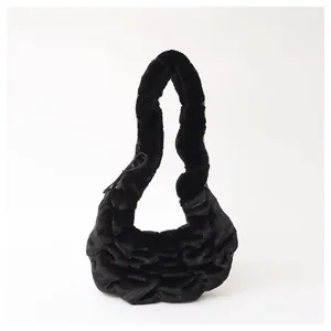 Detail van de pluchen rimpels en zachte textuur van deze zwarte faux fur croissant schoudertas