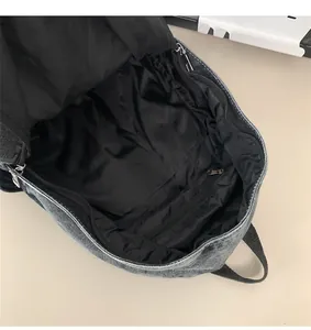 Vue intérieure du sac à dos en jean avec doublure noire et poche zippée fonctionnelle