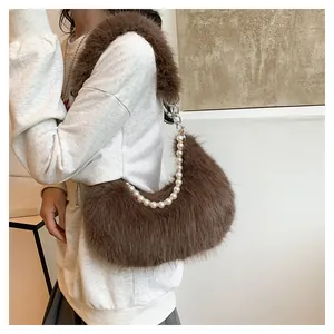 Détail d'un sac porté épaule en fausse fourrure marron avec chaîne de perles et anneau métal