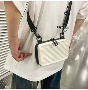 Detail of white hardshell crossbody bag featuring diagonal textured stripes and black zipper