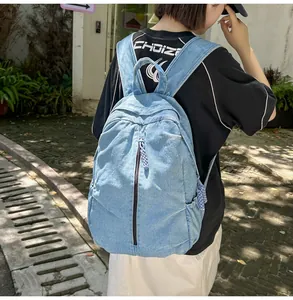 Vue arrière d'un sac à dos en jean bleu clair avec grande capacité et fermeture éclair verticale