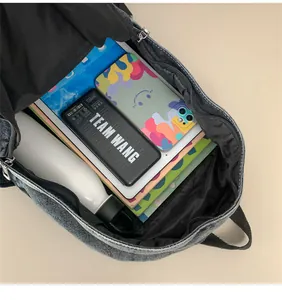 Vue macro de l'intérieur spacieux du sac à dos en denim avec des objets du quotidien